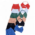 DUALLITY WEAR SET IMPACT STRAPPY: collection of ruched sports bras and shorts in red, light blue, green, peach, black, and blue. Features strappy back design and medium-high support.